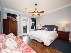 A bedroom with a bed, a wooden wardrobe, a nightstand, and a ceiling fan. - Family Friendly/Lagoon front w/Fishing Pier & Pool (Gulf Shores)