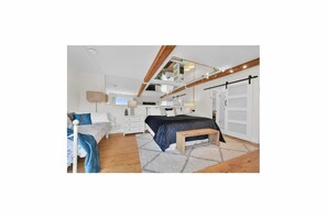 A modern bedroom with a bed, bedside tables, a bench, and a large mirror. - Riverfront Estate in Paris, 5 luxury Suites indoor pool hot tub self serve spa (Brant)