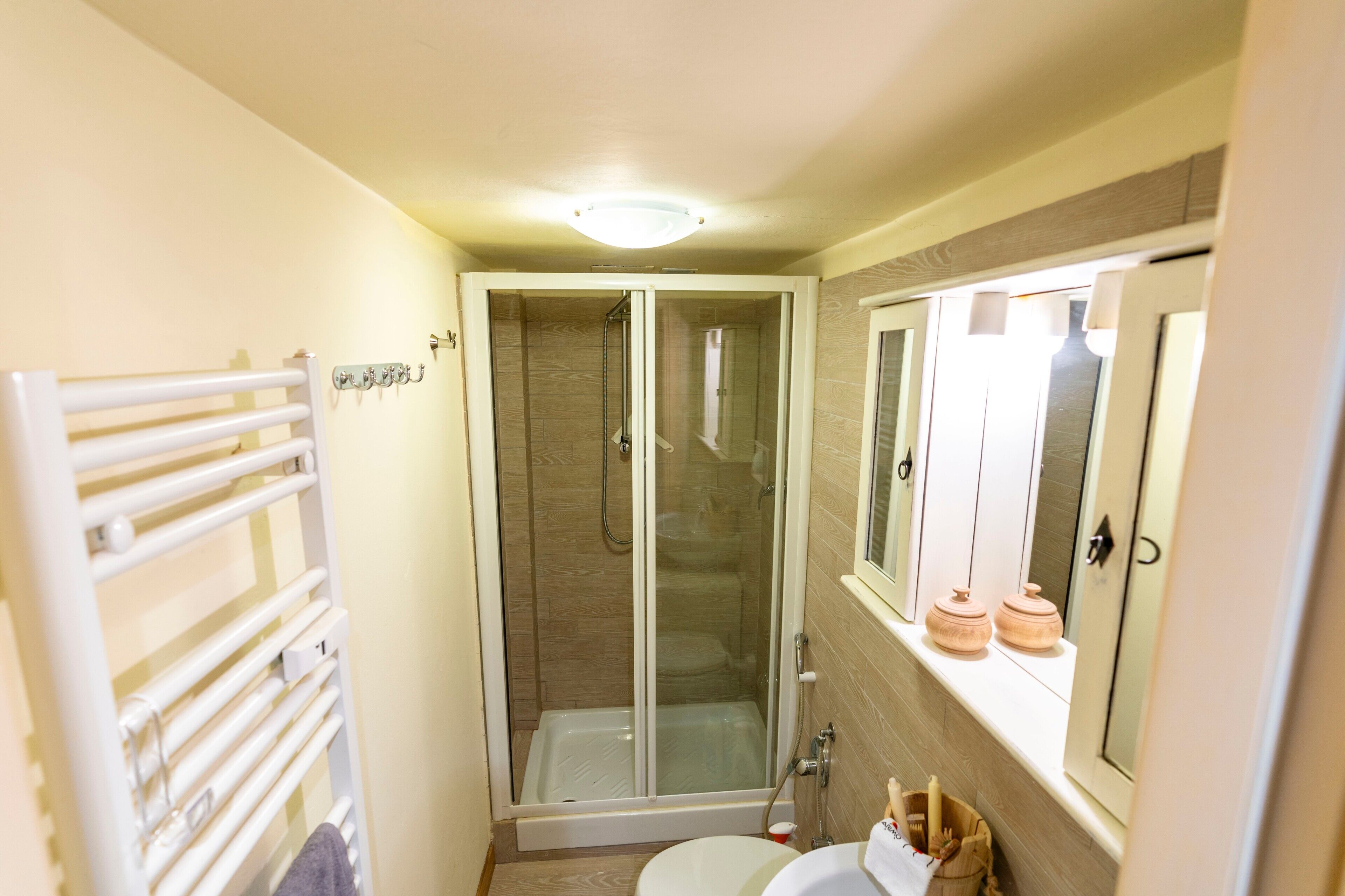 A bathroom with a glass-enclosed shower, a toilet, and a sink.