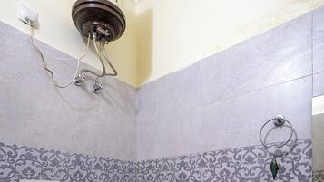 A bathroom with a toilet, a shower, and a sink.