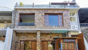A two-story building with a stone facade, wooden doors, and a balcony. - Dimmys By the Lake Bhimtal (Bhimtal)