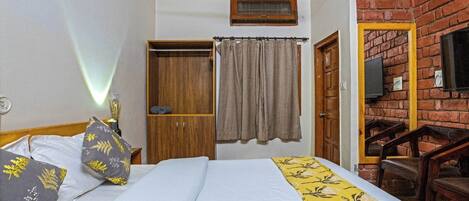 Une chambre à coucher avec un lit, une armoire, un rideau, une télévision et un mur en briques.