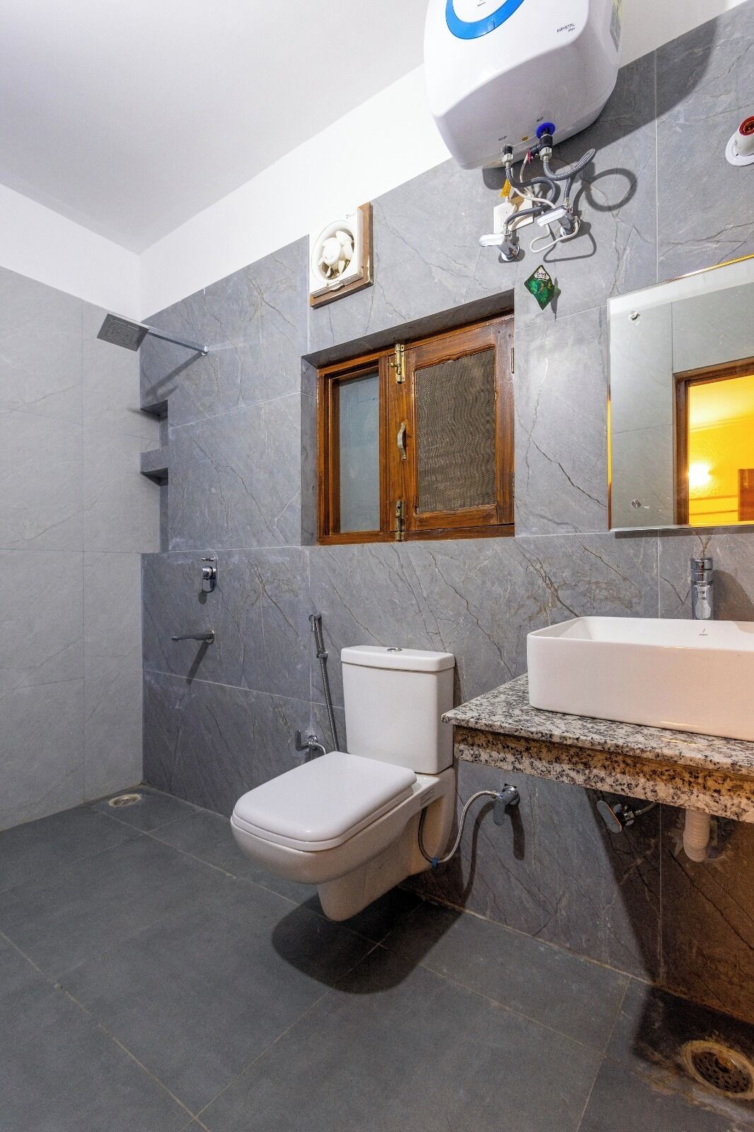 A modern bathroom with a toilet, shower, and sink.