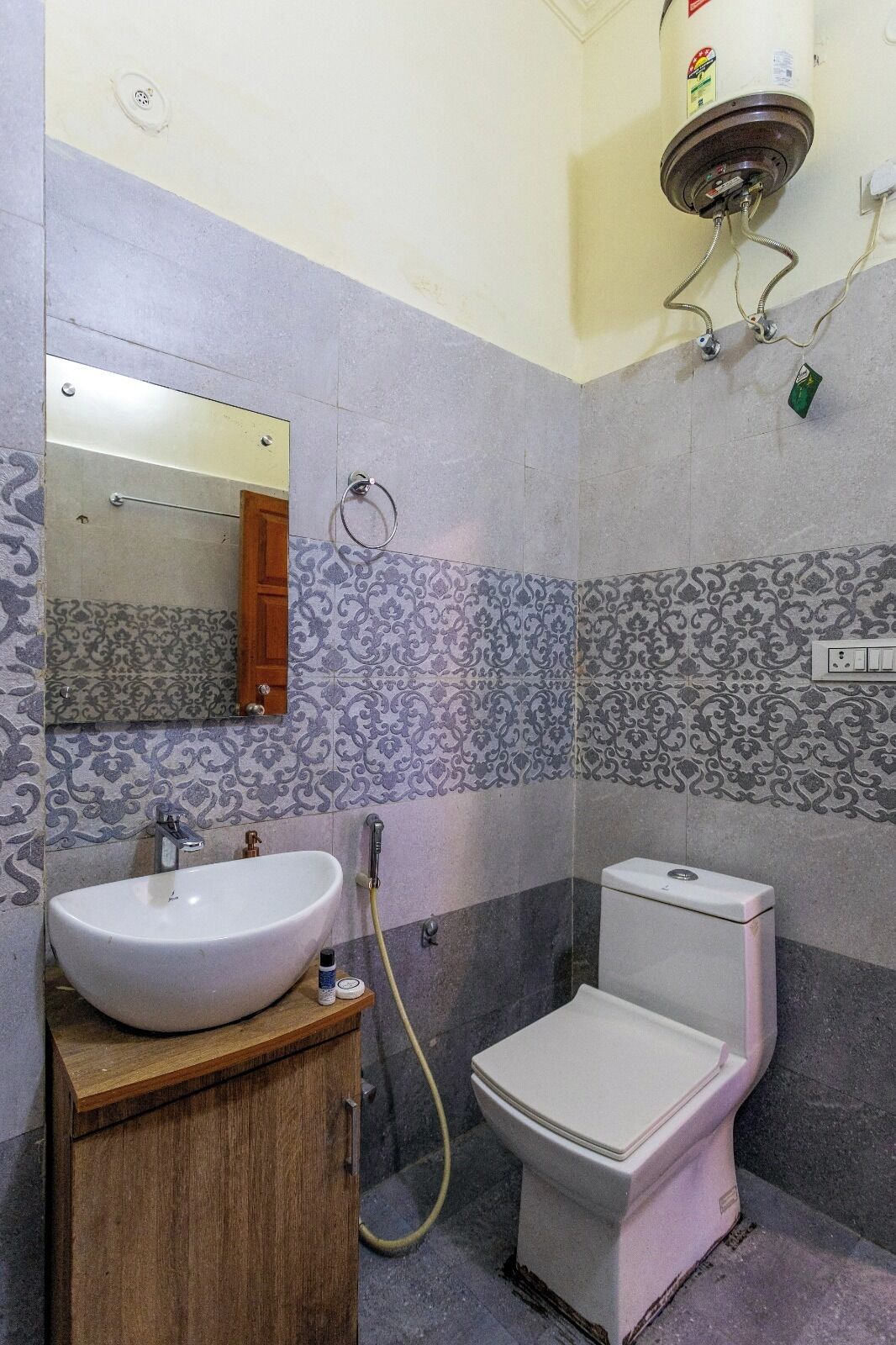 A bathroom with a sink, toilet, and mirror.