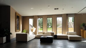 Un salon spacieux avec un grand canapé d’angle, une table basse et un tableau accroché au mur.