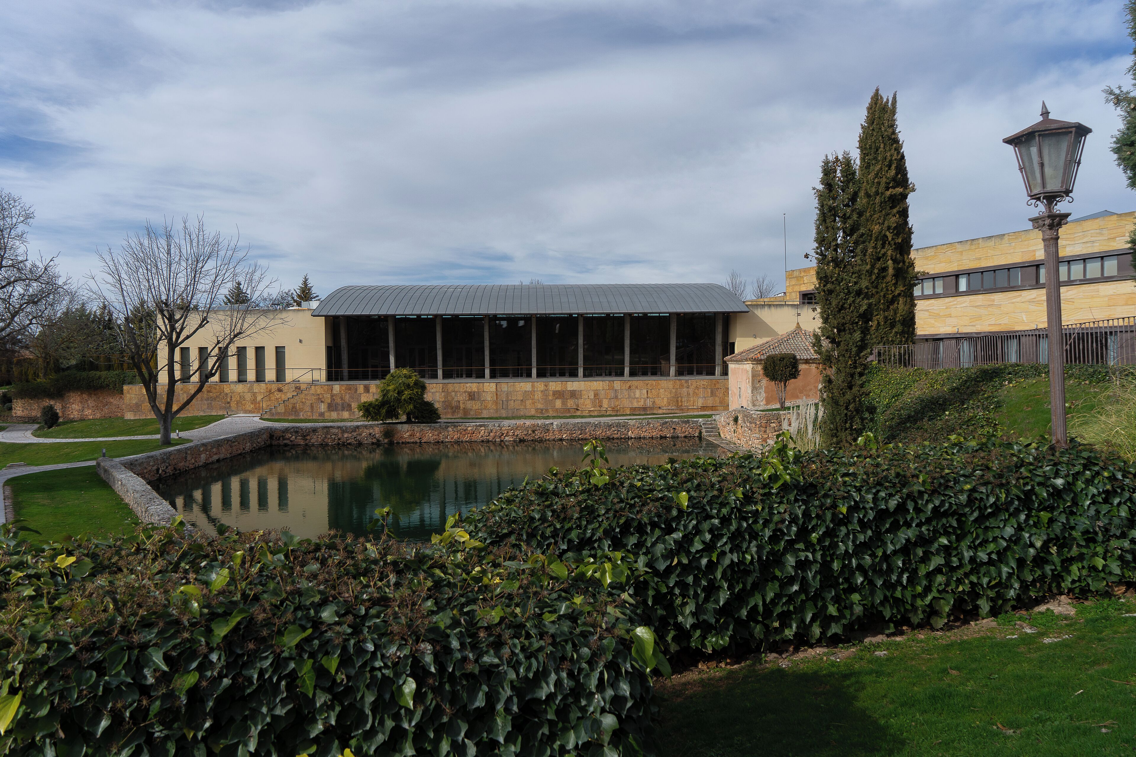 Edifici d'estil arquitectònic modern, amb un pati i una font, i un jardí ben cuidat.