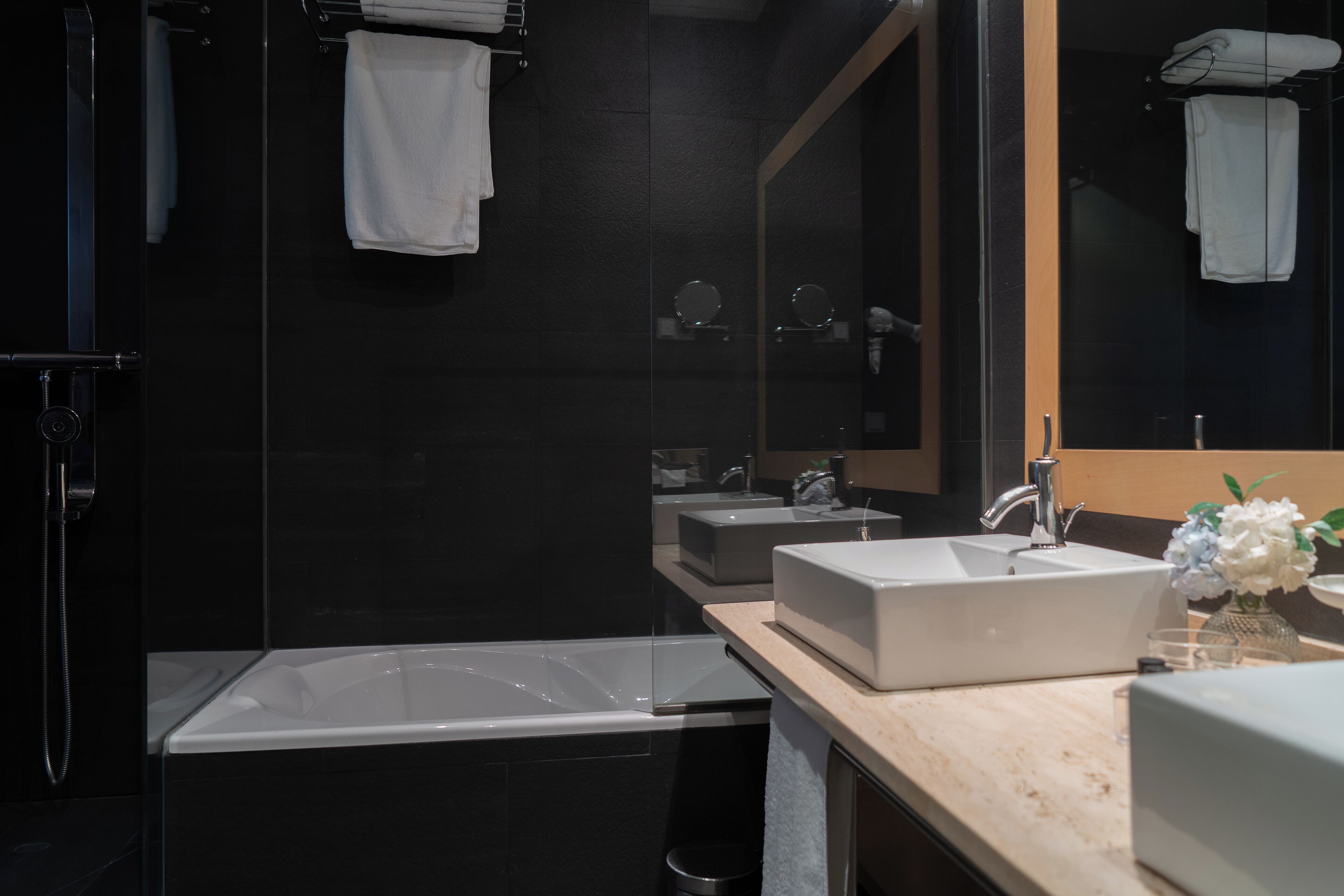 Ein modernes Badezimmer mit einer großen Badewanne, zwei Waschbecken und einem Spiegel.