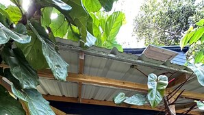Ein rustikales Holzgebäude mit einer großen Holztür und einer kleinen Veranda.
