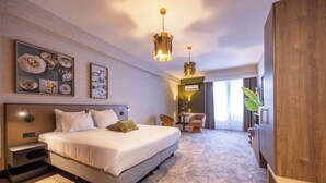 Ein modernes Hotelzimmer mit einem großen Bett, einem Schreibtisch und einer Sitzecke.