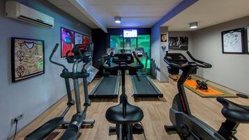 Een fitnessruimte met loopbanden, elliptische trainers en hometrainers.