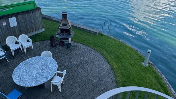 A terrace with outdoor seating, a grill, and a view of a lake with mountains in the background. - Line UP - 2,5 Zi Whg mit Seeanstoss - Beckenried (Beckenried)