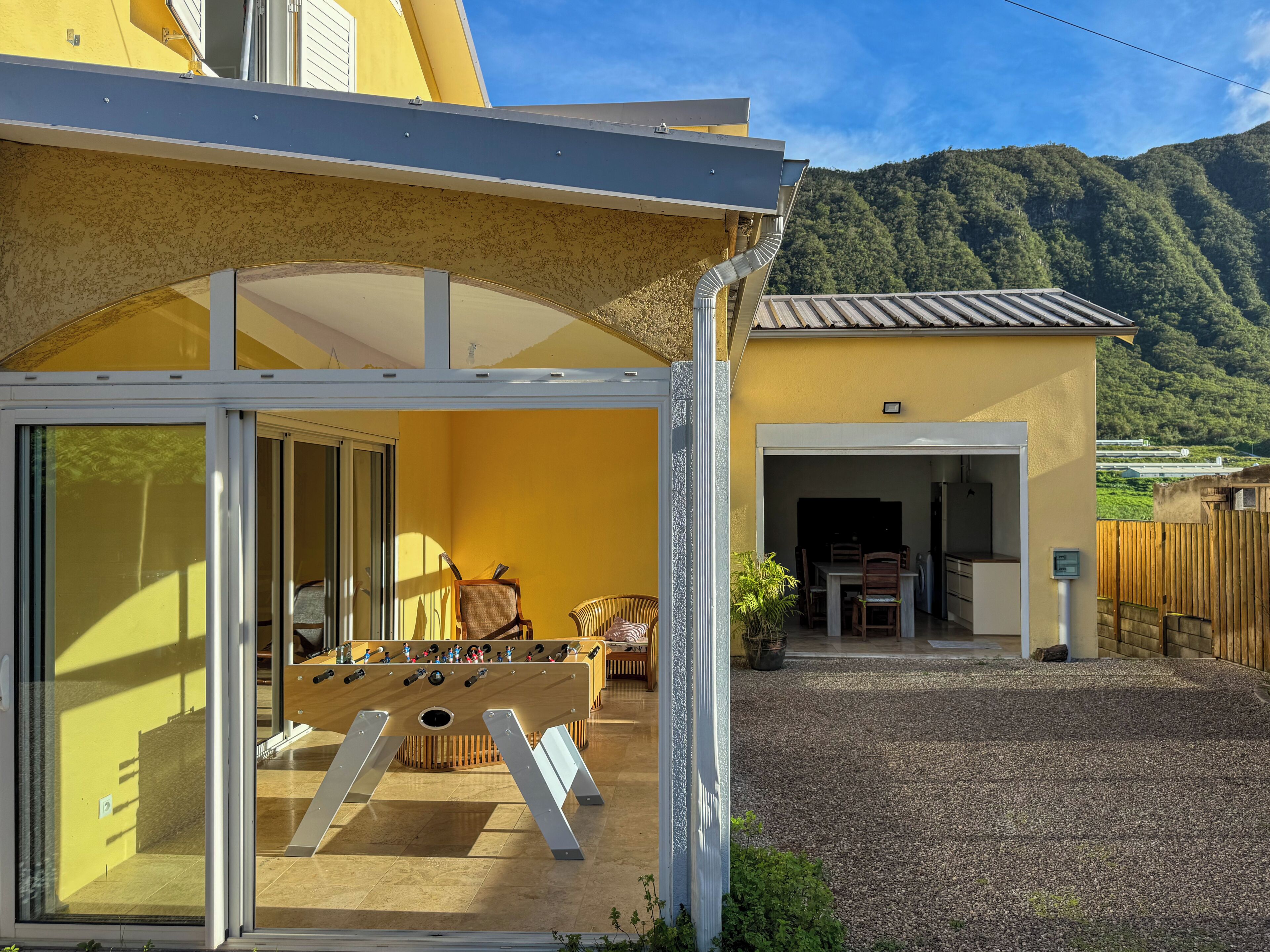 Un bâtiment jaune doté d’un patio couvert et d’un espace dédié à la salle à manger.