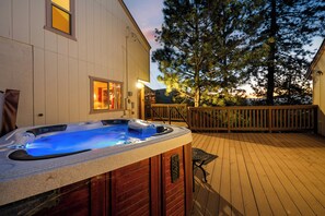 A hot tub on a wooden deck with a house and a tree in the background. - Panoramic Lake & Ski Slope Views | Hot Tub, Game Room & Garage (Big Bear Lake)