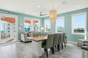 A spacious kitchen with a dining area, a ceiling fan, and a chandelier. - Graceful Palms (Gulf Shores)