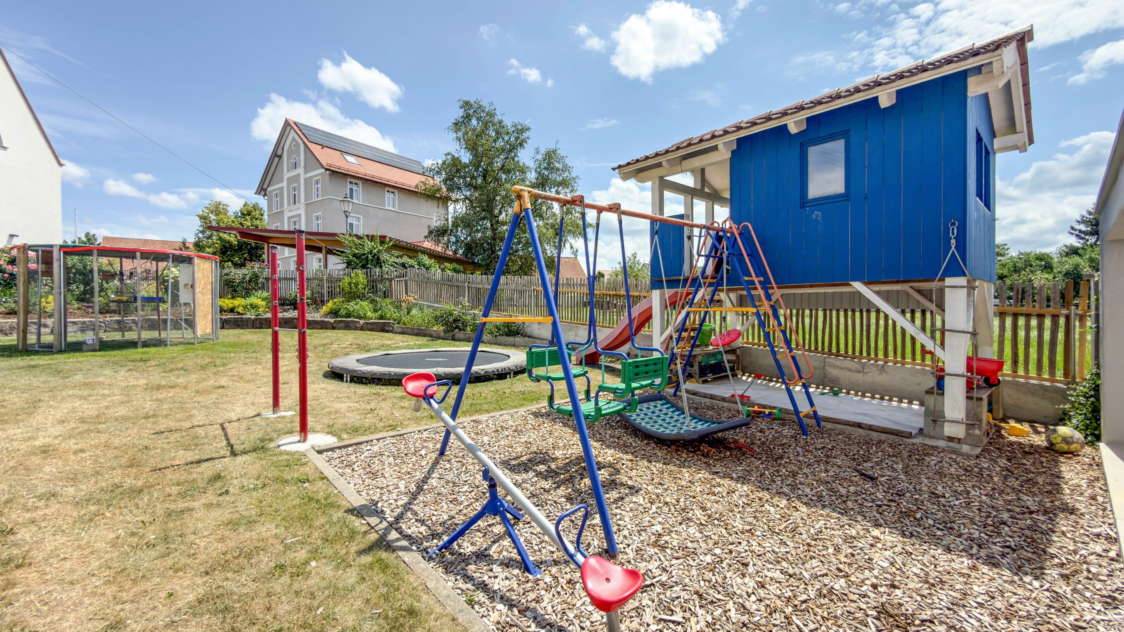A playground with swings, a slide, and a climbing structure.