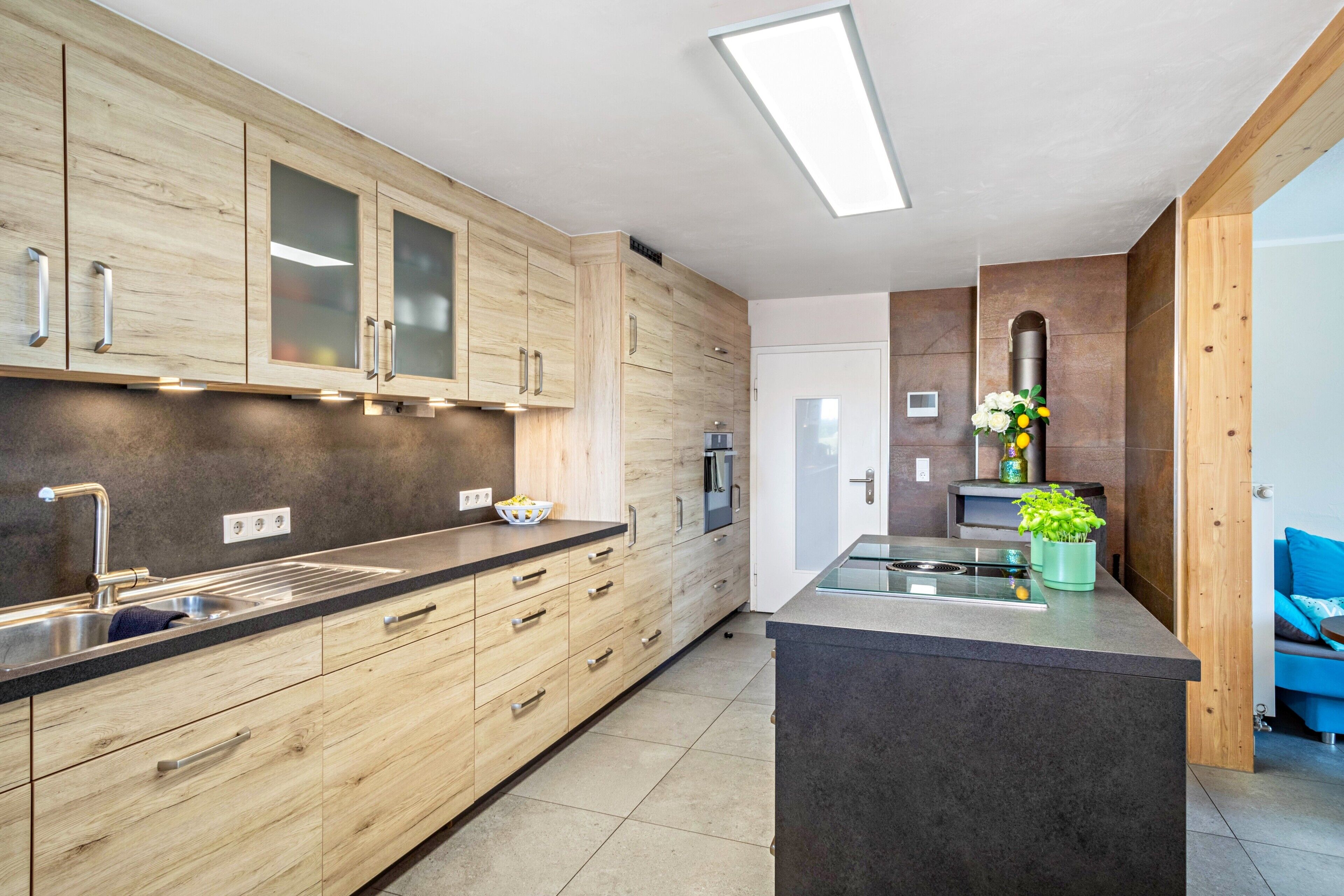 Una cucina moderna con mobili in legno, elettrodomestici in acciaio inossidabile e un'isola centrale.