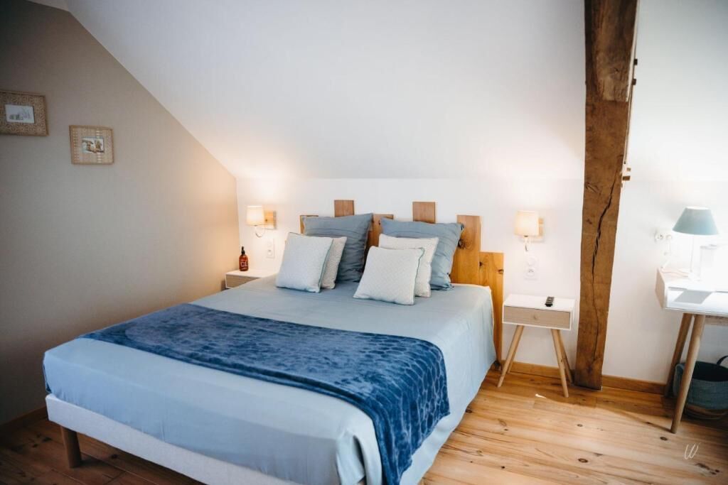 Un dormitorio con una cama, mesitas de noche y una lámpara.