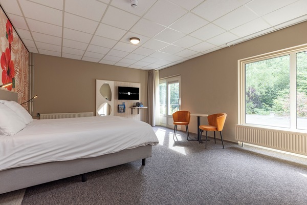 Lounge in sunlit comfort with wide windows and serene greenery.