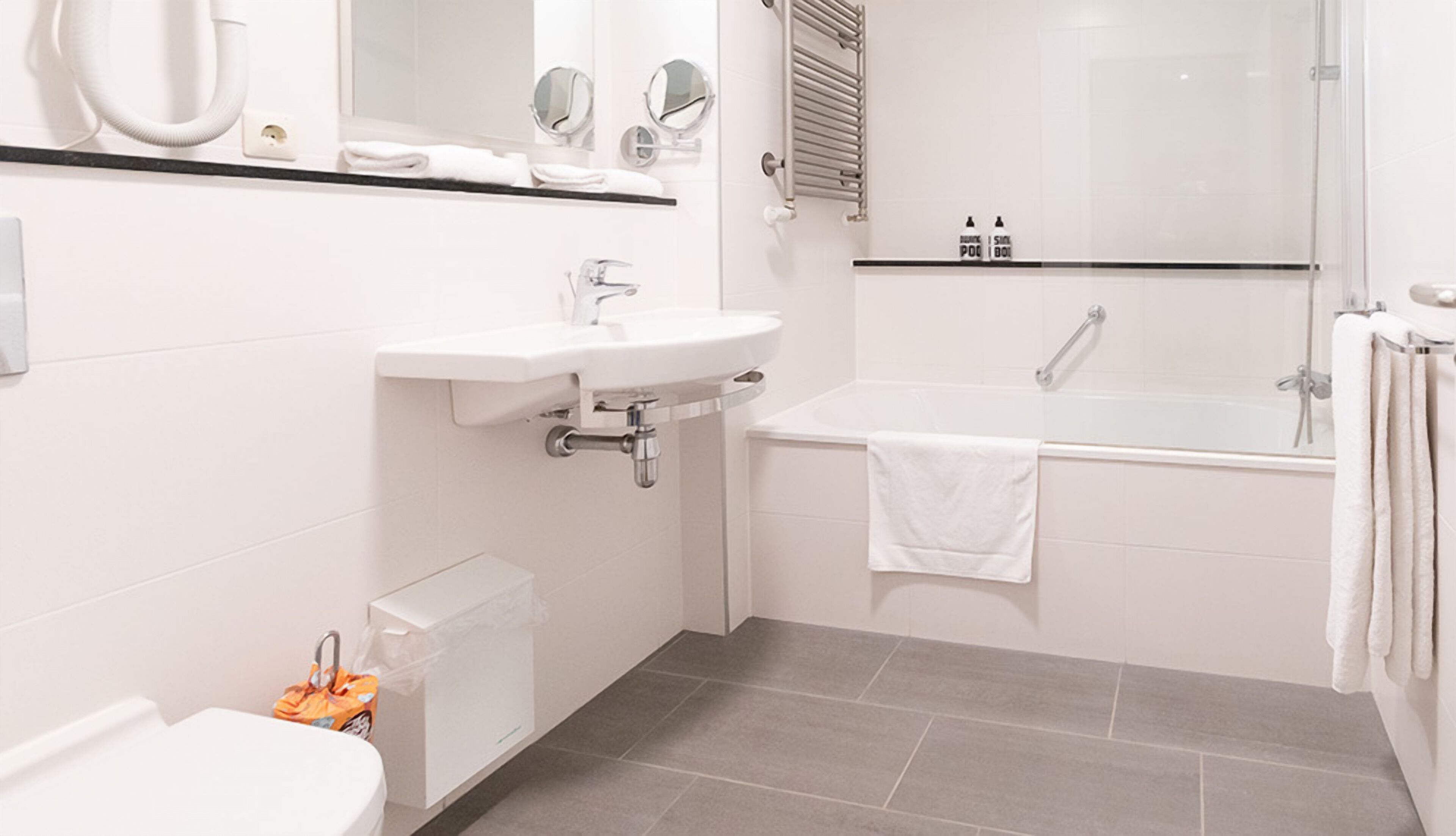Refresh with a sparkling bath, plush towels, and bright vanity.