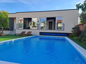 A modern house with a swimming pool, two lounge chairs, and a well-maintained garden. - Villa Nicoletta in Polaca (Polaca)
