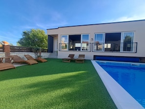 A modern house with a swimming pool, artificial grass, and wooden lounge chairs. - Villa Nicoletta in Polaca (Polaca)