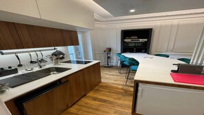 Eine kleine Küche mit Spüle, Holzschränken und einem kompakten Kühlschrank.