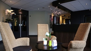 A reception area with wicker chairs, a round table, and a reception desk.