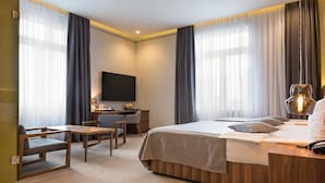 A modern hotel room with a bed, desk, and seating area. - Five Points Square - City Center (Belgrade)