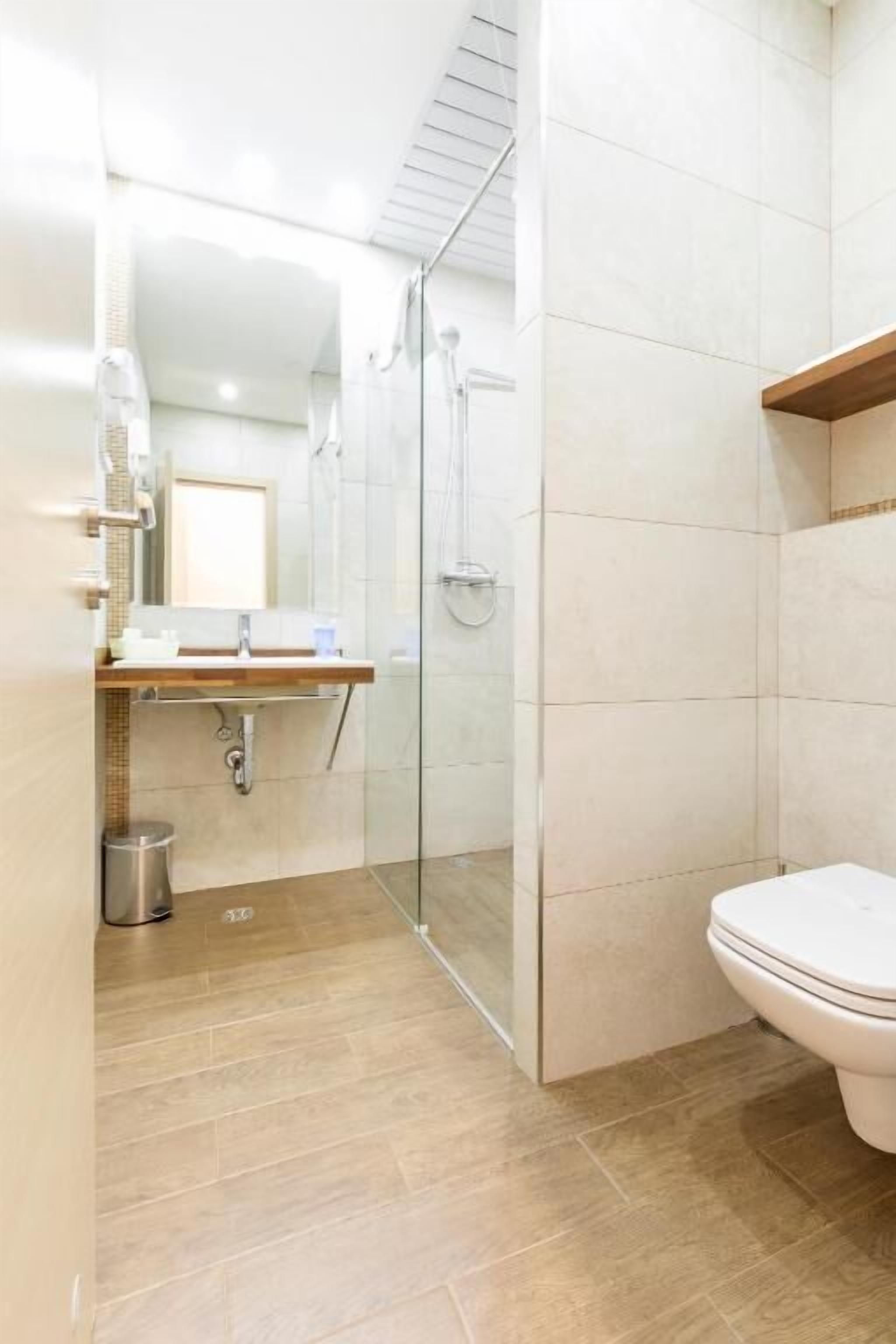 A bathroom with a shower, toilet, and sink.
