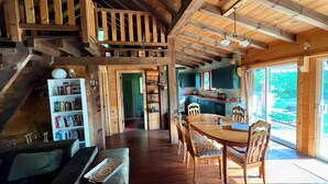 A wooden interior with a staircase, a dining area, and a kitchen. - The Loon Call: Gorgeous Lakefront Family Cottage (Ladysmith)