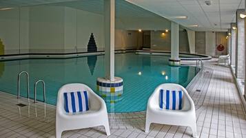 Unwind poolside on comfortable loungers beside shimmering indoor waters.