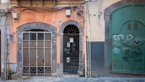 A building with a green door, a metal gate, and a small window. - Francy's Apartment with Balcony, Wi-Fi and Air Conditioning (Salerno)