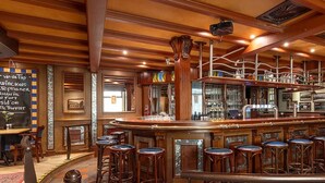 A bar area with wooden bar stools and a counter.