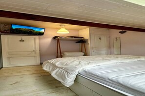 A bedroom with a bed, a television mounted on the wall, a ceiling light, and a wardrobe. - Waterfall View Stay for Family (Mont-Dore)