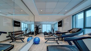 A modern gym with treadmills, exercise balls, and weight machines. - Kingsgate Hotel Clocktower (Dubai)