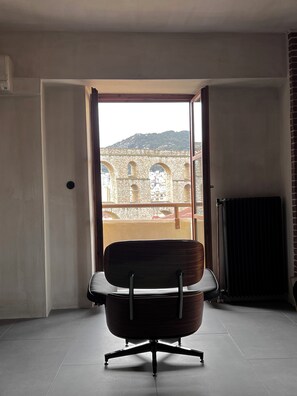 Une chambre moderne avec une grande fenêtre, une chaise et un radiateur.