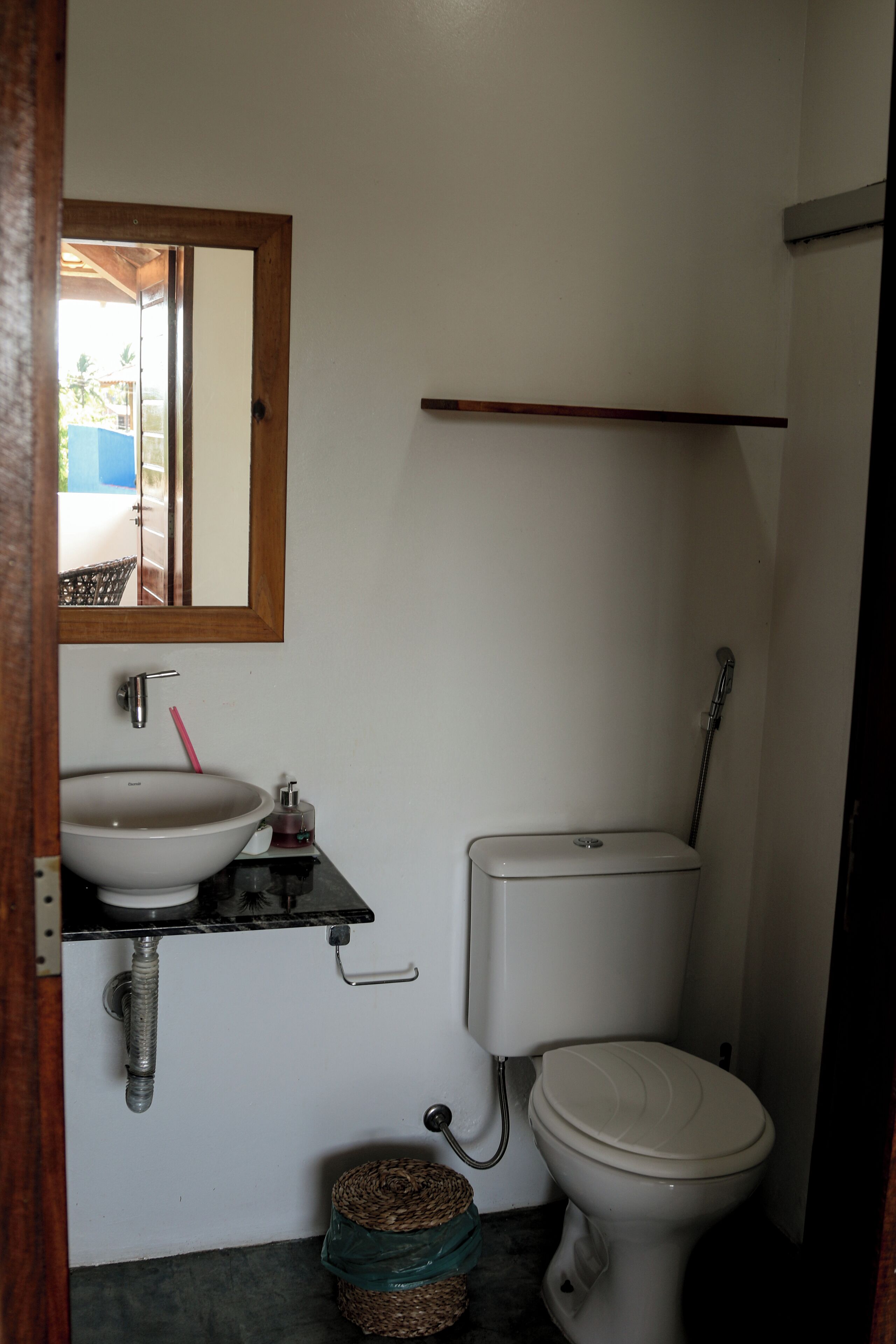 A small bathroom with a white sink, a toilet, and a mirror above the sink.