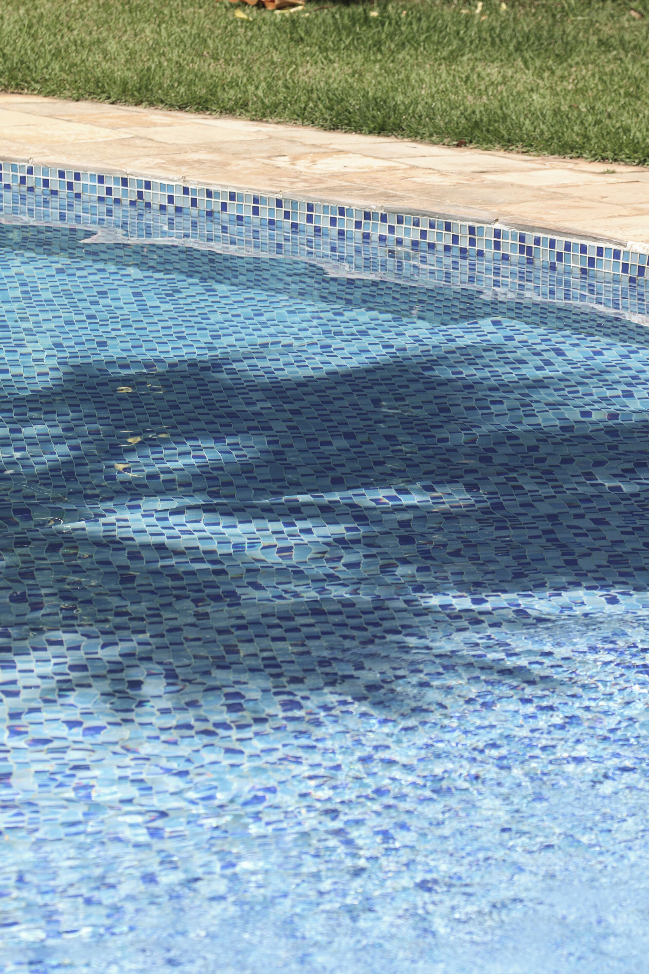 A swimming pool with a mosaic tile edge.