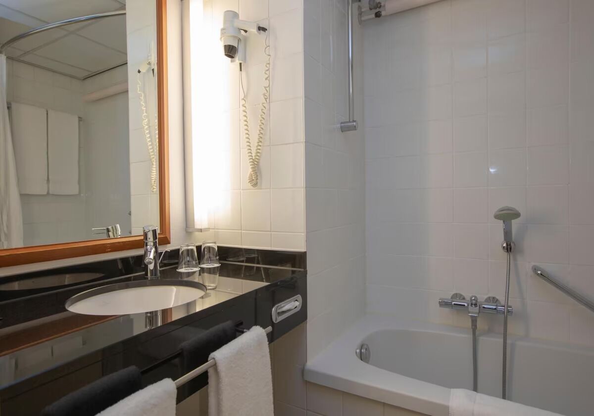 Une salle de bain équipée d’un lavabo, d’un miroir et d’une zone douche.