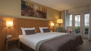 A hotel room with a large bed, two bedside lamps, a nightstand, a painting on the wall, and a view through the window.