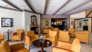 A hotel lobby with multiple seating areas, a fireplace, and a bar area.