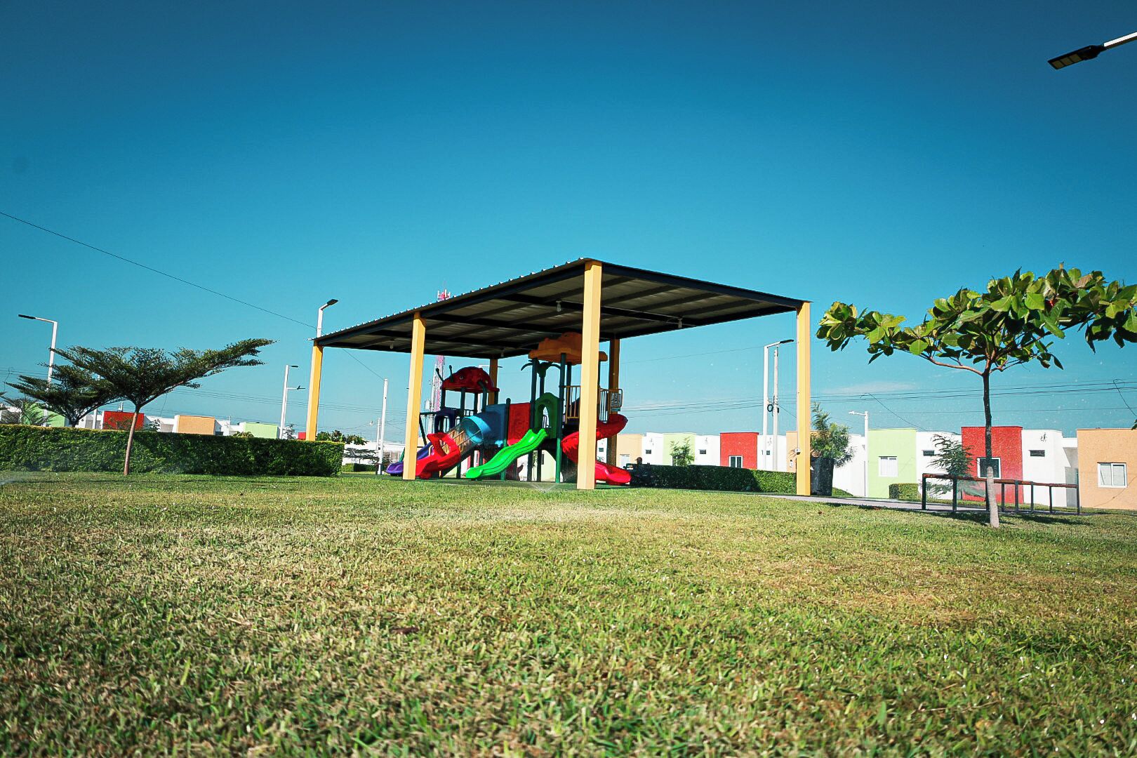 Un parque infantil con toboganes y un refugio cubierto.