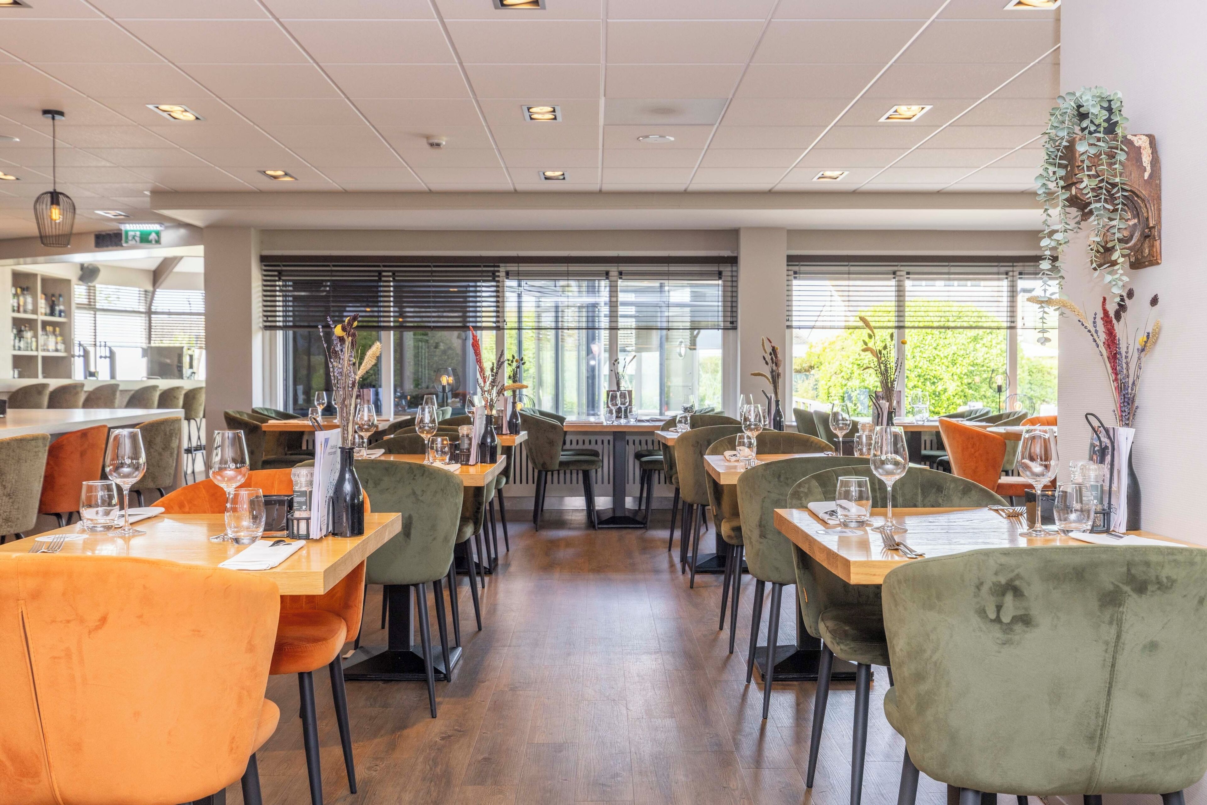A restaurant interior with multiple dining tables, chairs, and a bar area.