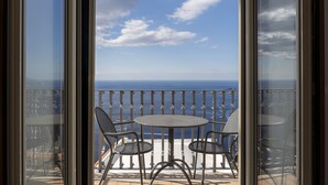 A balcony with a table and chairs, overlooking the sea. - Villa Deus by My Villa Collection (Nocelle)