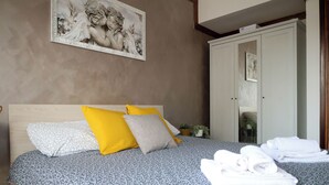 A bedroom with a bed, pillows, a wardrobe, and a painting on the wall. - Casa Carolina by Case al Lago (Desenzano del Garda)