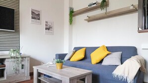 A living room with a blue sofa, wooden coffee table, and a small plant. - Casa Carolina by Case al Lago (Desenzano del Garda)