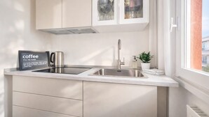 A modern kitchen with a stainless steel sink, a coffee station, and a view of the outside. - Casa Carolina by Case al Lago (Desenzano del Garda)
