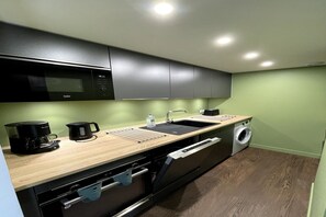 A compact kitchen with a microwave, coffee maker, sink, and washing machine. - Forest View Balcony Stay for 4 (Mont-Dore)