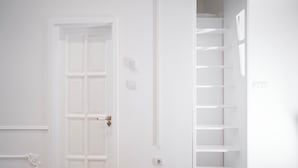 A white interior with a closed door, a wall socket, and a staircase with no steps visible. - Design Micro-Studio - 10 minutes to Central Station (Vienna)