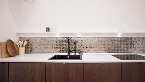 A modern kitchen with a black sink, wooden cabinets, and a mosaic backsplash. - Design Micro-Studio - 10 minutes to Central Station (Vienna)